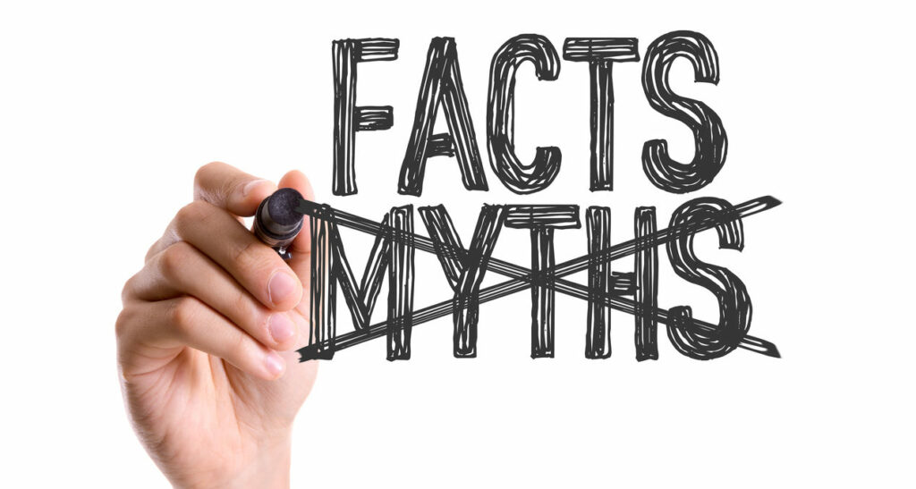 Hand with marker writing the word Facts Myths
